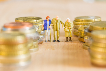 Retire elderly man and women take care by nursing home nurse with coin stack backgroundの写真素材