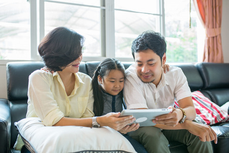 Asian Children reading book in living room.の写真素材
