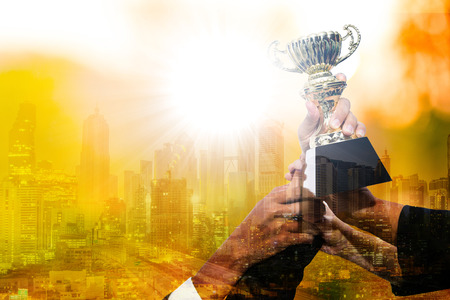 Businessman team show trophy for joyful together after successful business.Team work concept.の写真素材
