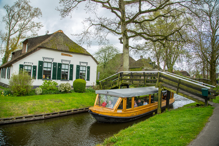 GIETHOORN, NETHERLANDS - April 22,2017: Tourist boat travel and visit Giethoorn village where call Venice of the North in Netherlands.のeditorial素材