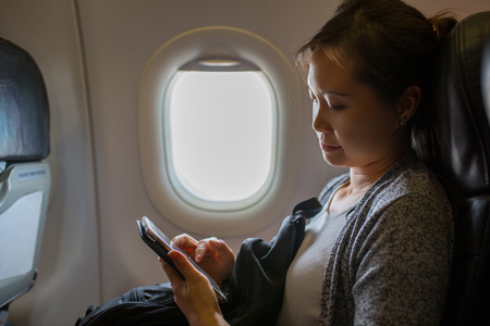 Passenger using smartphone for close to us airplane mode.