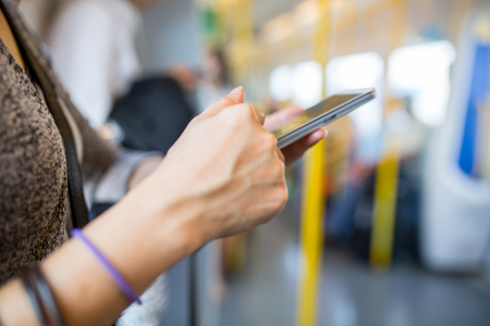 Woman using smartphone in train for search information.の写真素材