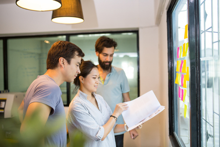 Three people smiling in the office for discuss business.の写真素材