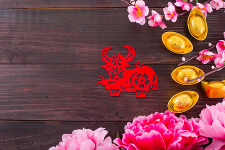 Year of  ox  red paper on the wood table.の写真素材