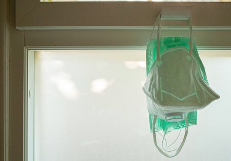 Mask protective corona virus or Covid - 19 hang on the windowの写真素材