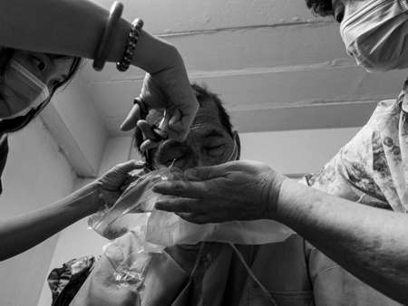 Daughter and his wife cut hair self at home for prevent coronavirus.Self cutting hair to father after pandemic from covid-19 that can't go out side to haircut at barbershop.の写真素材