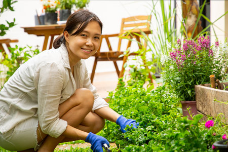 Gardening with jack russell terrier in the backyard.Asian woman trim grass in the garden with dog.Leisure activity lifestyle with pet in the outdoors.の写真素材