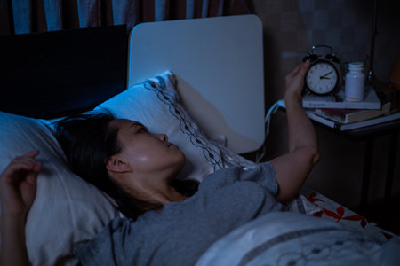 Reading book on the bed.Asian woman flip a book for read her books before sleep with Jack russell terrier dog.Learn and relax in the bedroom at night.の写真素材