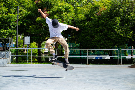 Skateboard man flip board in the sport area.Sport man funny with his hobby in the outside.の写真素材
