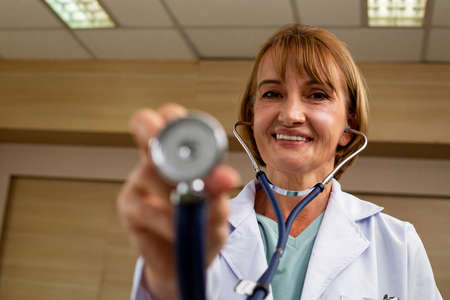 Medicare doctor holding stethoscope for support patient person in hospital.