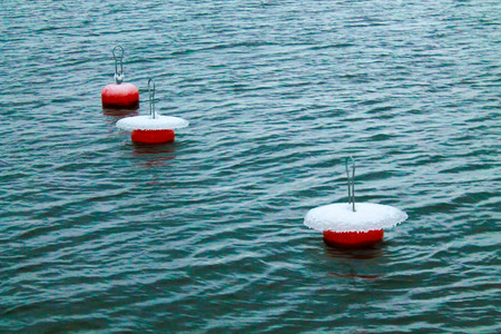 Three mooring buoys with ice and snow on topの写真素材