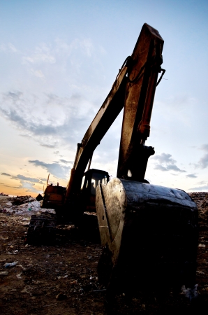 silhouette excavator near garbage heapの写真素材