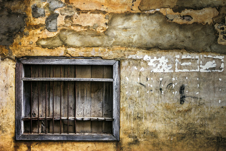 An old window in a facade of abandoned houseの写真素材