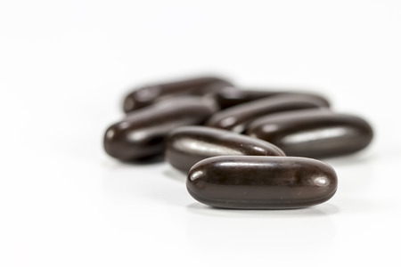 Brown pills and pill bottle on white background.の写真素材