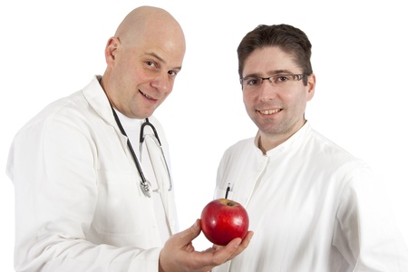 Two doctors posing while holding an appleの写真素材