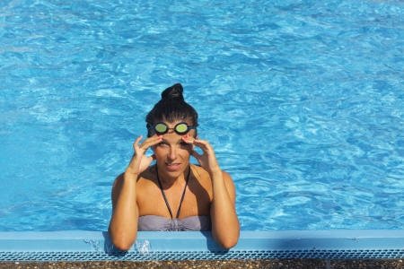 Pretty young female swimmer posing in swimming poolの写真素材