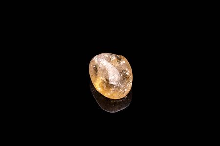 Citrine gemstone isolated on black background. Macro shot.