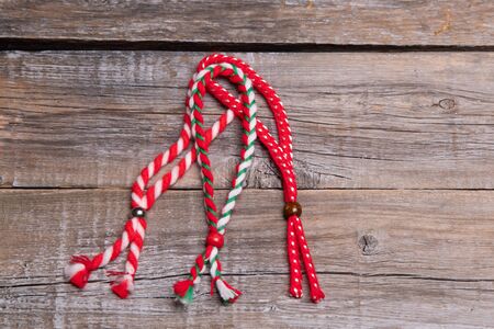 Bulgarian traditional spring decor martenitsa bracelets on wooden background.の写真素材