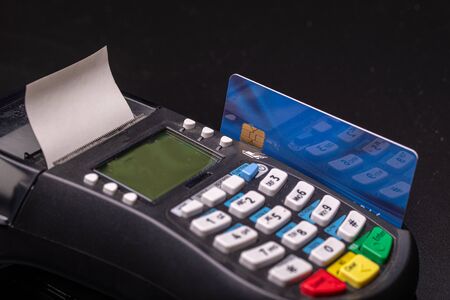 POS terminal, Payment Machine with credit card on black background. Contactless payment with NFC...