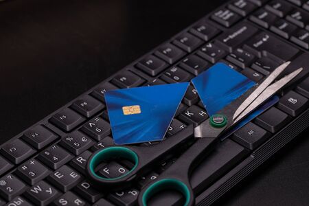 Cutting up a credit card with scissors. Demonstrating either paid off or bankrupt and the card is no good any more.の写真素材