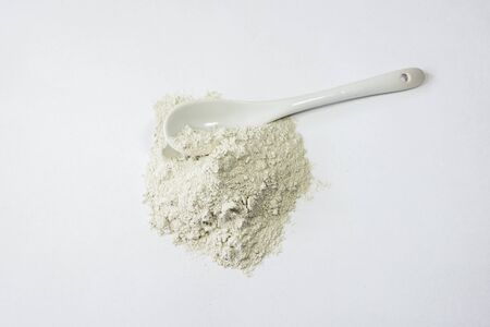 Zeolite mesolite raw powder and spoon on white background. Macro shotの写真素材