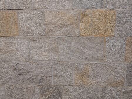 Textured stone walls built of large stones held together by dark lumps of white cement limestone