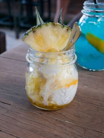 Pineapple smoothie with fresh pineapple  and Blue curacao cocktail on wooden backgroundの写真素材