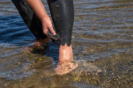 Woman applying on her body salty healing mud in Pomorie lake,Bulgariaの写真素材