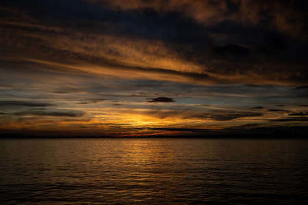 Inspirational calm sea with sunset sky. Meditation ocean and sky background. Sandy beach at sunrise. dramatic ocean scenery with cloudy sky.の写真素材