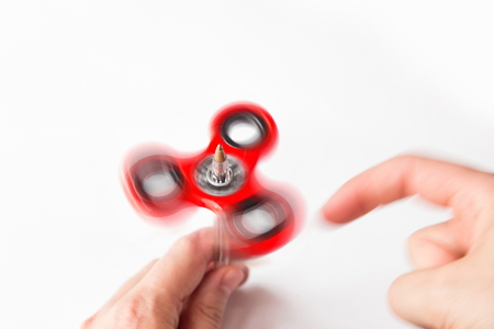 man playing with fidget spinner using a pen to rotate it, isolated on white background, motion blur effectの写真素材