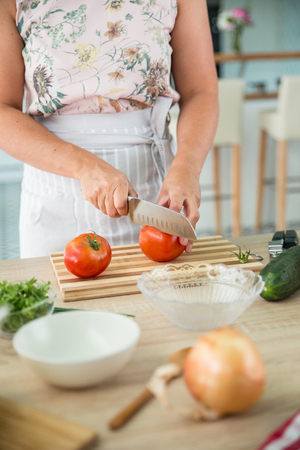 anonymous chef chopping tomatoes for preparing a gazpacho, spanish traditional cold soupの写真素材