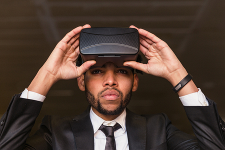 afro businessman adjusting his virtual reality glassesの写真素材
