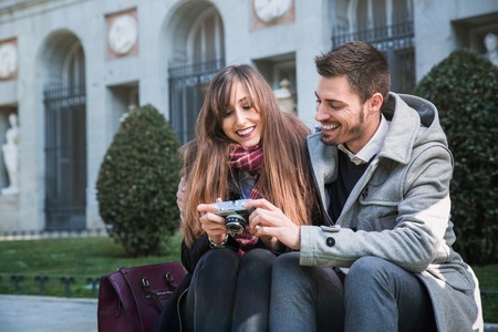 Couple of tourists, a man and a woman, taking pictures in the city of Madrid, Spainの写真素材