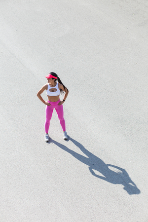 Female athletic runner in park in the summer, resting after a jog, fitness and healthy lifestyle conceptの写真素材