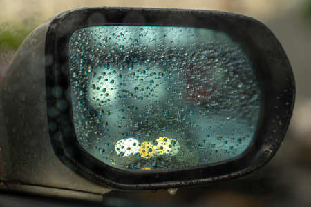 Raindrop outside the car in raining day. Raindrops on car window and rear view mirror. wing mirror....