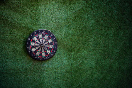 Darts hitting the bullseye of a dart board backgroundの写真素材
