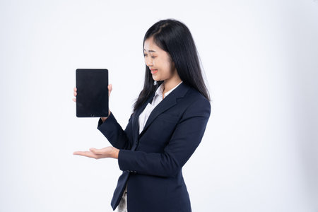 Portrait of corporate woman reads news, works on her digital tablet while on her way to office, Business woman portrait, holding a tablet in his handの写真素材