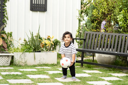 Cute little boy playing soccer with ball outdoors on soccer fieldの写真素材