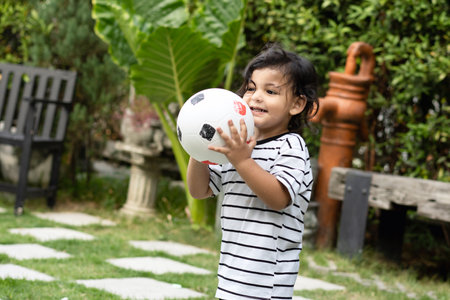 Cute little boy playing soccer with ball outdoors on soccer fieldの写真素材