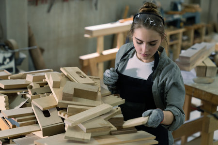 Portrait of young female carpenter working with wood in her workshopの写真素材