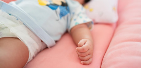 Newborn baby lying on a pink sofa. Shallow depth of field.の写真素材