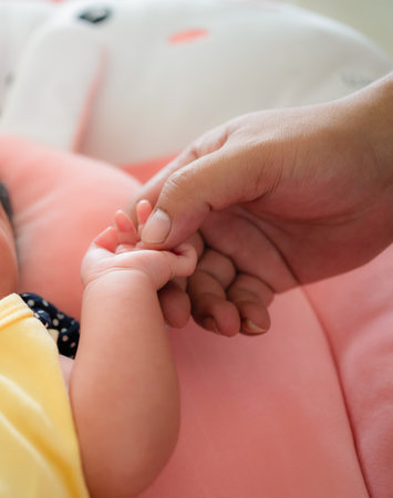 Newborn baby hand holding mother's hand, shallow depth of fieldの写真素材