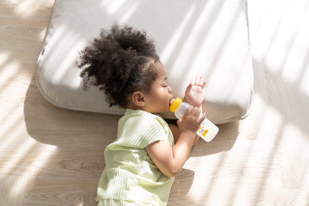 Cute baby girl drinking milk sleeping on the roomの写真素材