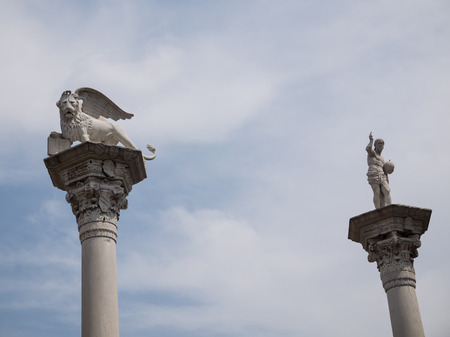 Statue of a winged lion and Jesus on two colums on the Piazza dei Signori in the town of Vicenzaの写真素材