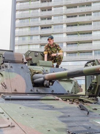 ALMERE, NETHERLANDS - 23 APRIL 2014: Soldier sitting on a Dutch military armored fighting vehicle on display during the National Army Day in Almere which can be inspected by the general public at close rangeのeditorial素材