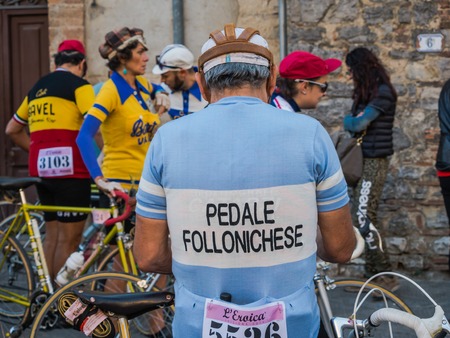 GAIOLE IN CHIANTI, ITALY - 5 OCT. 2014: Unidentified participants of L\'Eroica, a touristic and historic cycling event for owners of vintage bicycles who ride a tour in vintage clothing through the province of Tuscany, mainly on white gravel roads.のeditorial素材