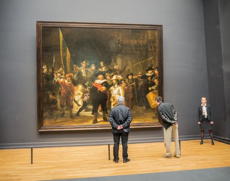 AMSTERDAM - 2 JULY 2014: Tourists in one of the rooms of national Rijksmuseum scrutinize the world famous Nightwatch painting by Rembrandt. The musuem attracts more than 2 million visitors each yearのeditorial素材