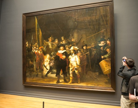 AMSTERDAM - 2 JULY 2014: Tourist in one of the rooms of national Rijksmuseum takes a picture of Rembrandt's world famous Nightwatch. The musuem attracts more than 2 million visitors each yearのeditorial素材
