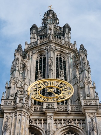 Detail of the facade of the Antwerp cathedral showing the golden clock on the tower near the Great Square Grote Markt in Antwerp, Belgiumの写真素材