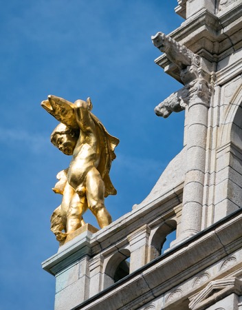 Golden statue of a boy carrying a giant fish on the historic 'Visschers Huizeken', a former fisherman' s home, a landmark building along Meir street in Antwerp, Belgiumの写真素材
